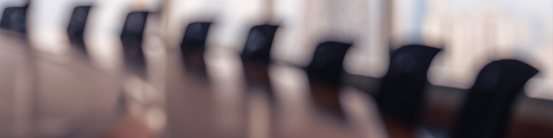 Leadership skills image - Blur image of empty boardroom with window cityscape background.